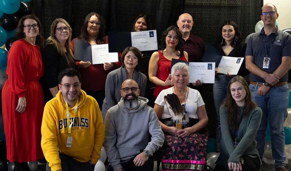 Group photo of workshop participants and organizers, several holding certificates of participation